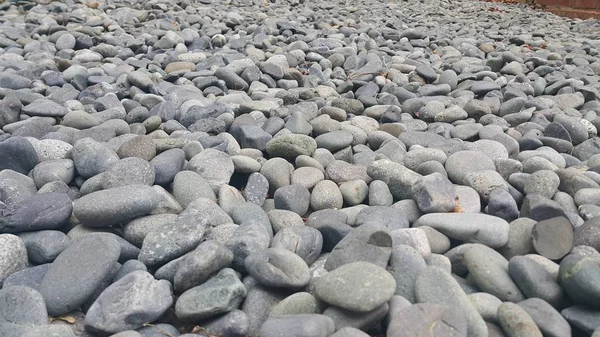 Rotskeien, kleine, ronde, gladde rotsen. Textuur achtergrond voor tekst — Stockfoto