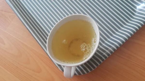 Vista superior del té verde en una taza colocada en una bandeja sobre un piso de madera —  Fotos de Stock