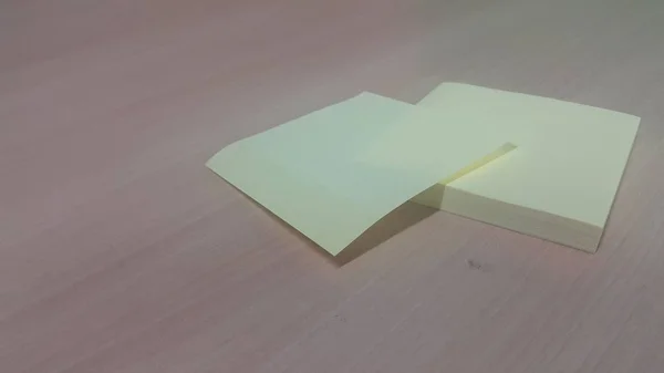 Sárga ragacsos papír egy fa asztalra helyezve — Stock Fotó