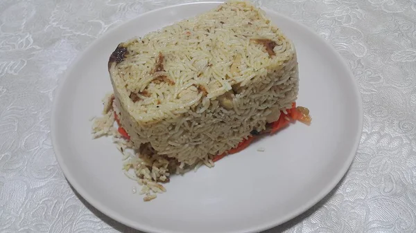 Primer plano de pastel de arroz blanco congelado en un plato blanco sobre piso de madera —  Fotos de Stock