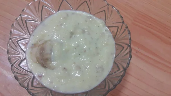 Zoete witte rijst pudding in een glazen kom met bananen schijfjes gelaagd op het oppervlak — Stockfoto