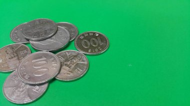 Kore Won sikke yeşil bir zemin üzerinde dağılmış