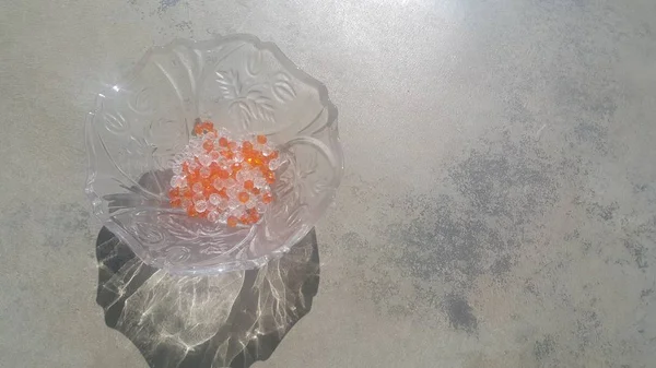 Glänzende, transparente, orangefarbene Kristallperlen oder Edelsteine in einer Glasschale — Stockfoto