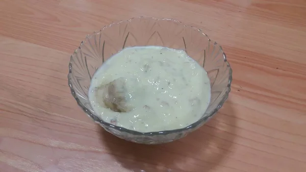 Pouding de riz blanc sucré dans un bol en verre avec des tranches de banane en couches sur la surface — Photo