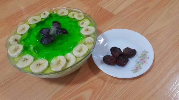 Romige smakelijke zoete groene gelei met bananen schijfjes gelaagd op het oppervlak — Stockfoto