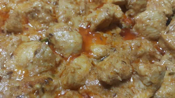 Een close-up van gestoofde kippenvlees blokjes met specerijen erop — Stockfoto