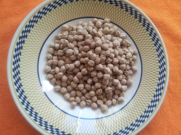 Garbanzos secos orgánicos crudos en plato — Foto de Stock