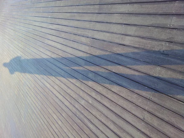 Тінь людини на коричневій дерев'яній підлозі — стокове фото