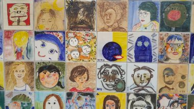 Anılar için duvardaki insanların resimleri ve heykel yüzleri.