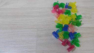 Ahşap bir zemin üzerine yerleştirilen renkli küçük holding klipleri bir sürü
