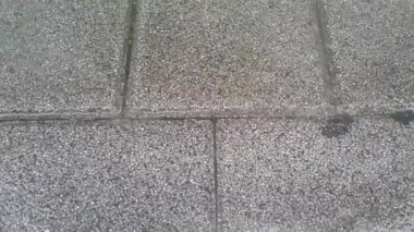 Gri tuğlalar üzerinde dalgalanma yapan yağmur su damlaları yakından görünümü