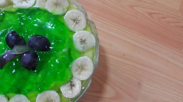 Gelée verte douce crémeuse avec des tranches de banane superposées à la surface — Photo