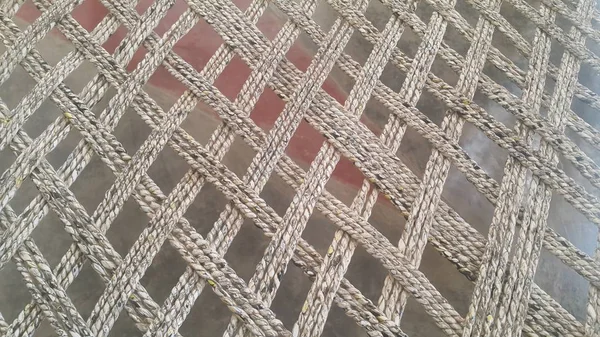 Suszone nici juty lub liny przeplatają się do produkcji tradycyjnego łóżka zwanego charpai — Zdjęcie stockowe