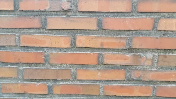 A background of a weathered old exterior brick wall in the sunshine. — Stock Photo, Image