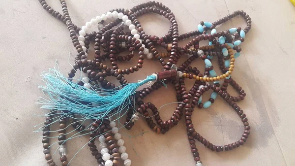 Beautiful wooden prayer beads or rosary placed over fabric background — Stock Photo, Image