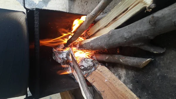 Fuego sobre troncos en maceta con brasas y carbón ardiendo y llamas ardientes . —  Fotos de Stock