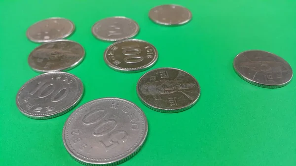 Koreaanse won munt verspreid over een groene vloer — Stockfoto
