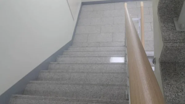Gri beton merdivenlerin ahşap korkuluk yakın görünümü. — Stok fotoğraf