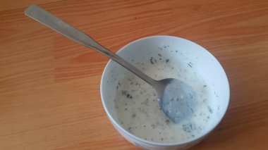 Gümüş kaşıkla beyaz seramik kasede sade lor veya yoğurt veya dahi yakın