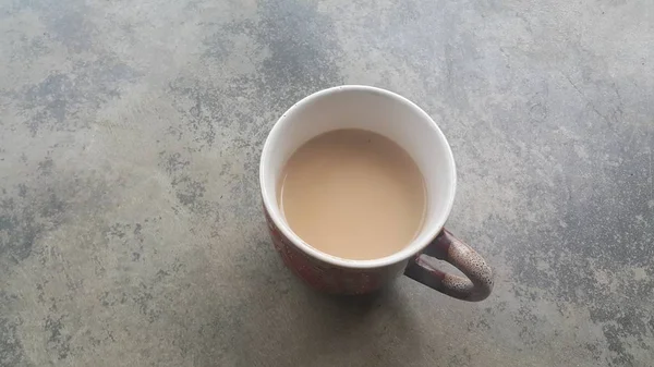 Cangkir putih kopi yang indah dengan susu hitam-teh di atas lantai — Stok Foto