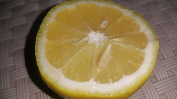 Свежие ломтики лимона с желтыми пилингами помещены на серый пол — стоковое фото
