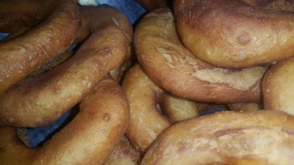 Nahaufnahme einer Reihe frisch zubereiteter brauner und leckerer Donuts. — Stockfoto