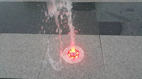 Hermosa y colorida fuente de agua ligera sobre piso de hormigón — Foto de Stock