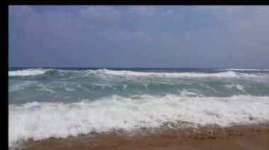 Yaz aylarında güneş ışığı üzerinde plaj denizi görünümü. Okyanus dalgaları kumlu kıyı üzerinde ileri geri hareket