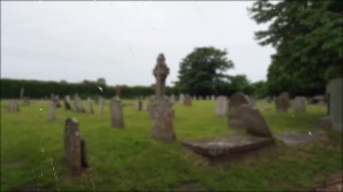 Mezarlık yeşil otlak ve yeşil yaprakları temiz havada hareket eden ağaçlar yağmur manzarası ile bir ayna üzerinde yağmur damlaları yakından görünümü