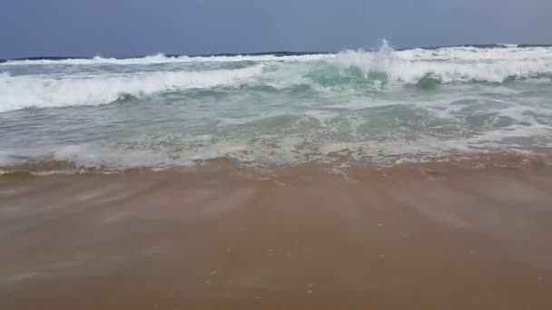 夏の太陽の光のビーチ海の眺め 砂浜の土地を行ったり来たりする海の波 — ストック動画