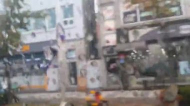 Arkasında bulanık pazar manzarası ile bir araba pencere aynasında yağmur damlaları yakından görünümü 