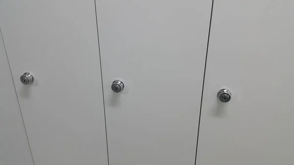 Перспективный вид шкафчиков или шкафов в ряд с белыми дверями — стоковое фото
