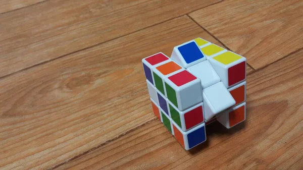 Vista de perto do cubo de Rubik no chão de madeira — Fotografia de Stock