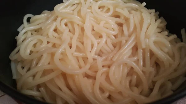 Vista da vicino di tagliatelle vorticose o pasta di spaghetti — Foto Stock