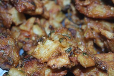 Kıtır havza pakora / pakoda veya köftelerin seçici odaklı yakın plan görüntüsü, yeşil salata ve sosla servis edilen popüler Hint veya Pakistanlı sokak yemekleri. Seçici odak