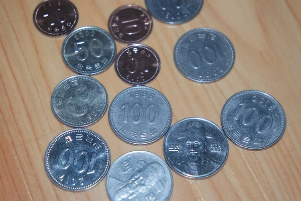 Gümüş parlayan Kore won 'u ahşap zemine saçılmış..