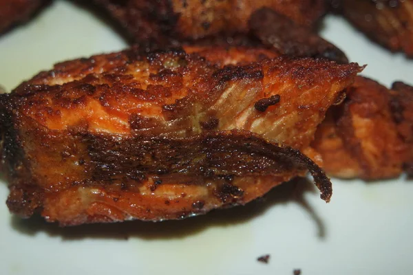 Beyaz arka planda kızarmış balık filetosunun baharatlı ve çıtır çıtır barbeküsü. Sağlıklı beslenme için ev yapımı alabalık bifteği..