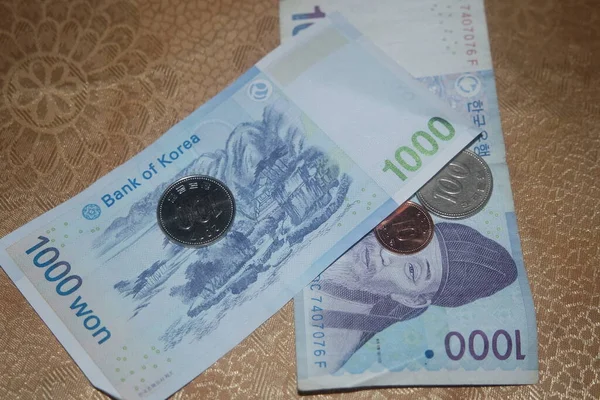 Серебряная Сияющая Корейская Монета Разбросана Корейским Банкнотам Деревянном Полу — стоковое фото