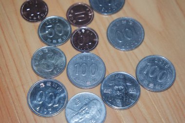 Gümüş parlayan Kore won 'u ahşap zemine saçılmış..