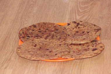 Geleneksel paratha - Makro yakın plan ev yapımı yağlı ekmek veya ahşap bir tabakta parotta odaklı. Chapati, Güneydoğu Asya 'nın geleneksel gıdasıdır..