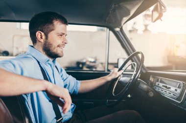 Yakışıklı adam onun eski eski model araba içinde oturuyor