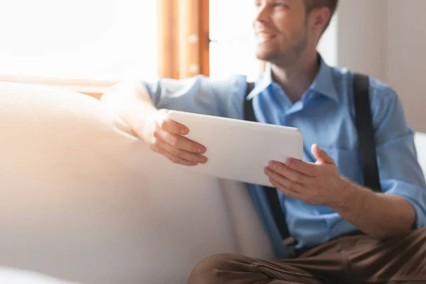 Knappe Man Zittend Bank Thuis Met Behulp Van Een Digitaal — Stockfoto