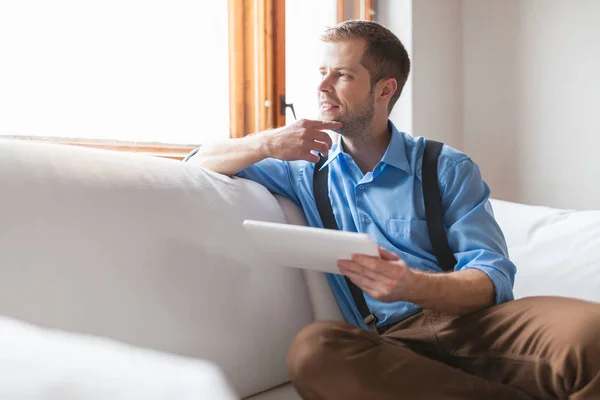 Knappe Man Zittend Bank Thuis Met Behulp Van Een Digitaal — Stockfoto