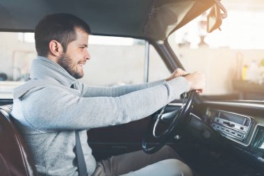 Yakışıklı adam onun eski eski model araba içinde oturuyor