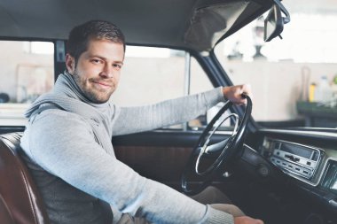 Yakışıklı adam onun eski eski model araba içinde oturuyor
