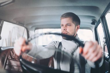 Yakışıklı adam onun eski eski model araba içinde oturuyor