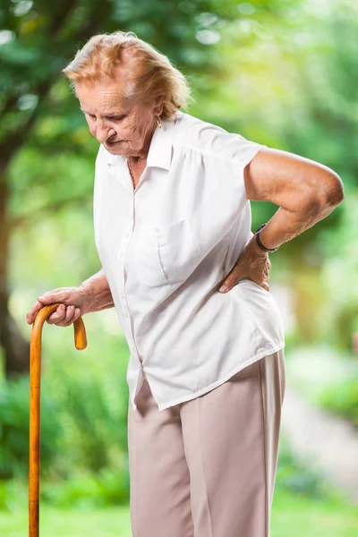 Bejaarde Vrouw Buitenshuis Met Pijn Onderrug — Stockfoto