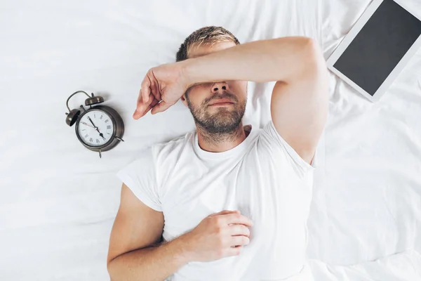 Yorgun Bir Adam Onun Dijital Tablet Kullandıktan Sonra Yatağa Yatıyor — Stok fotoğraf