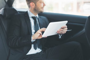 Dijital tablet kullanma araba arkasında oturan çift iş adamı
