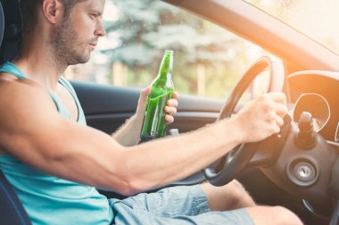 Sarhoş sürücü direksiyon başında içki içiyor.
